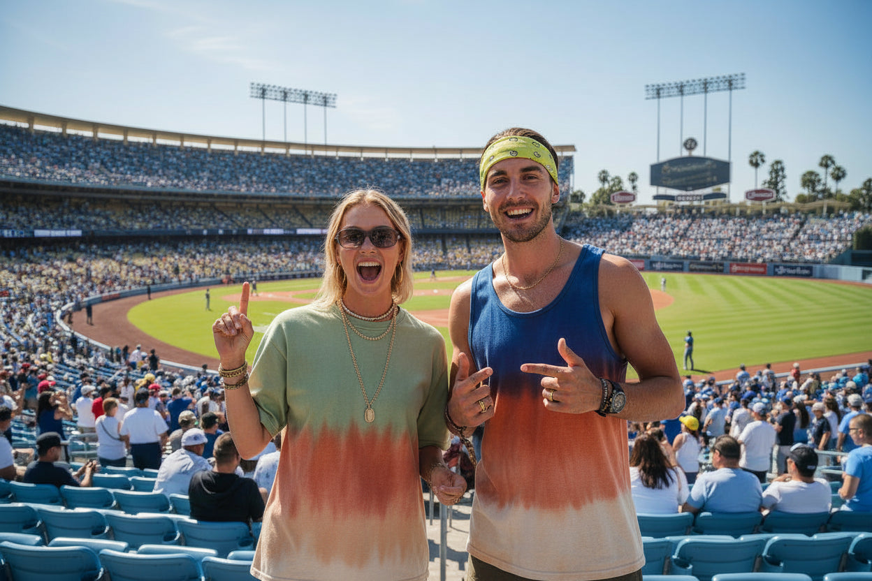 Two people wearing tie-dye shirts at a baseball stadium.